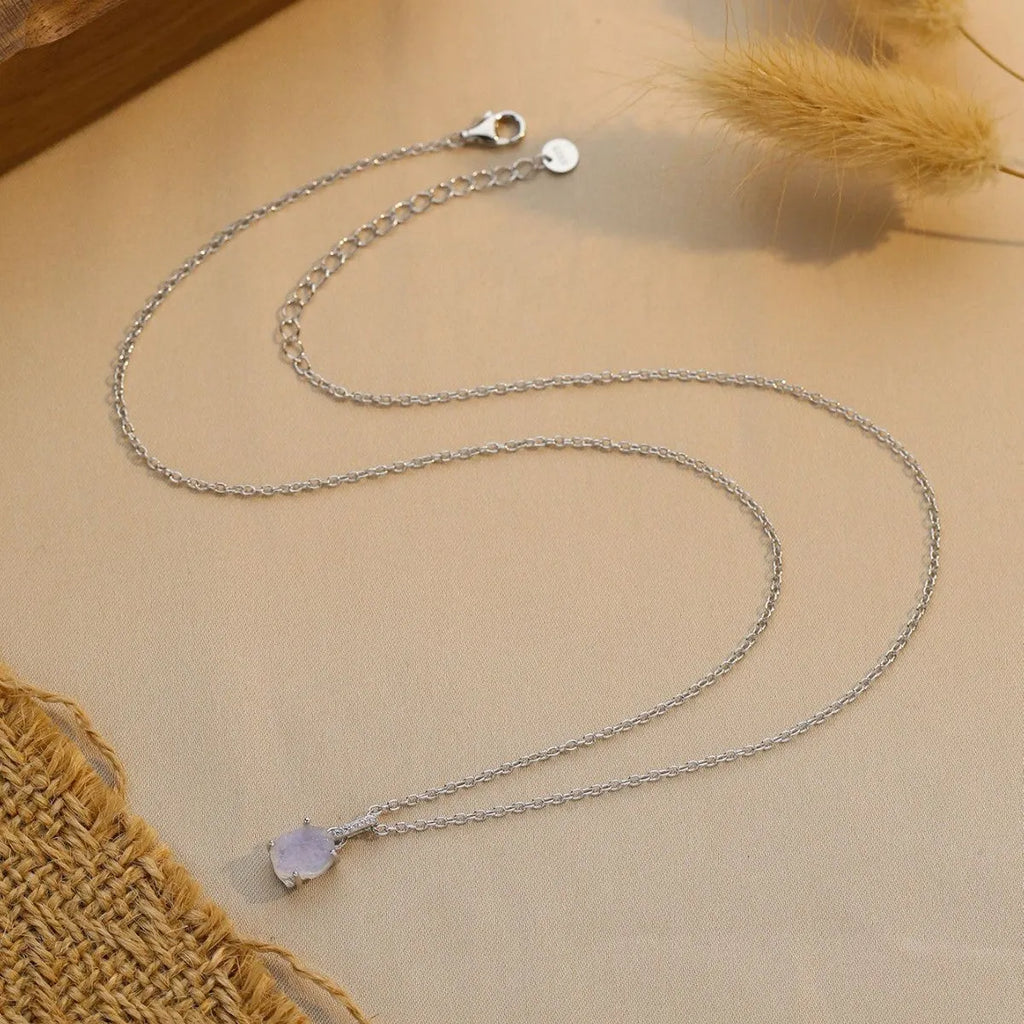 Close-up of a sterling silver necklace with a square moonstone pendant on an adjustable curb chain.