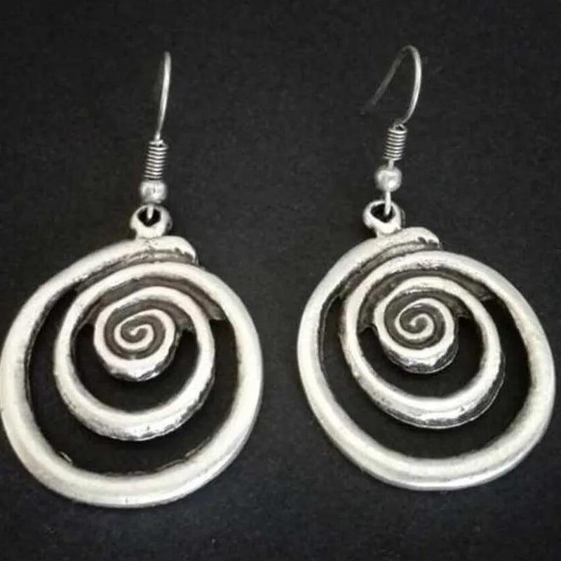 Pair of silver geometric spiral earrings with a distressed finish on a white background.