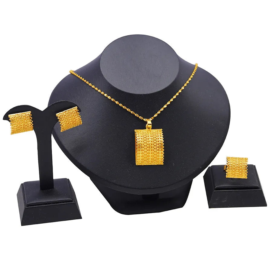 Golden bridal jewellery set comprising a copper necklace, earrings, and ring on a display.