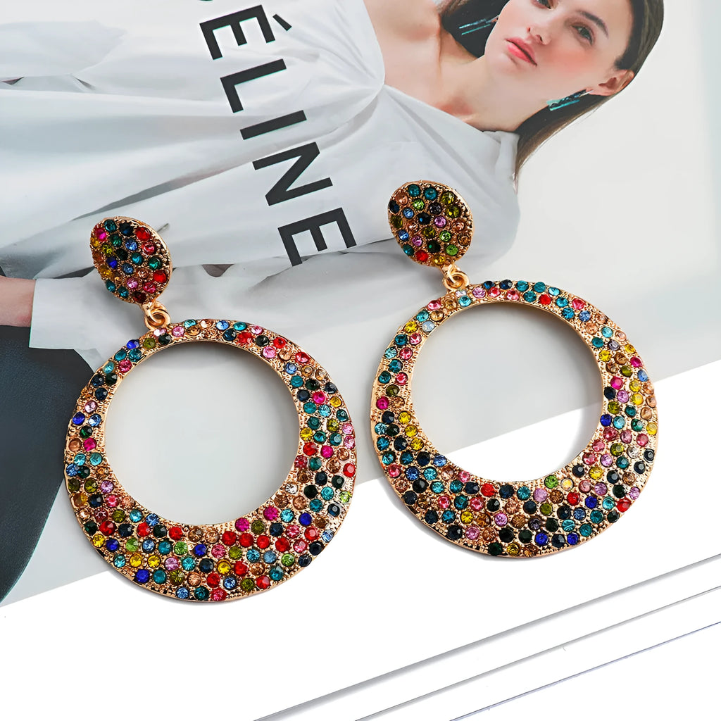 Colourful large pendant earrings with round diamond-shaped studs on a cartoon-style metal setting.