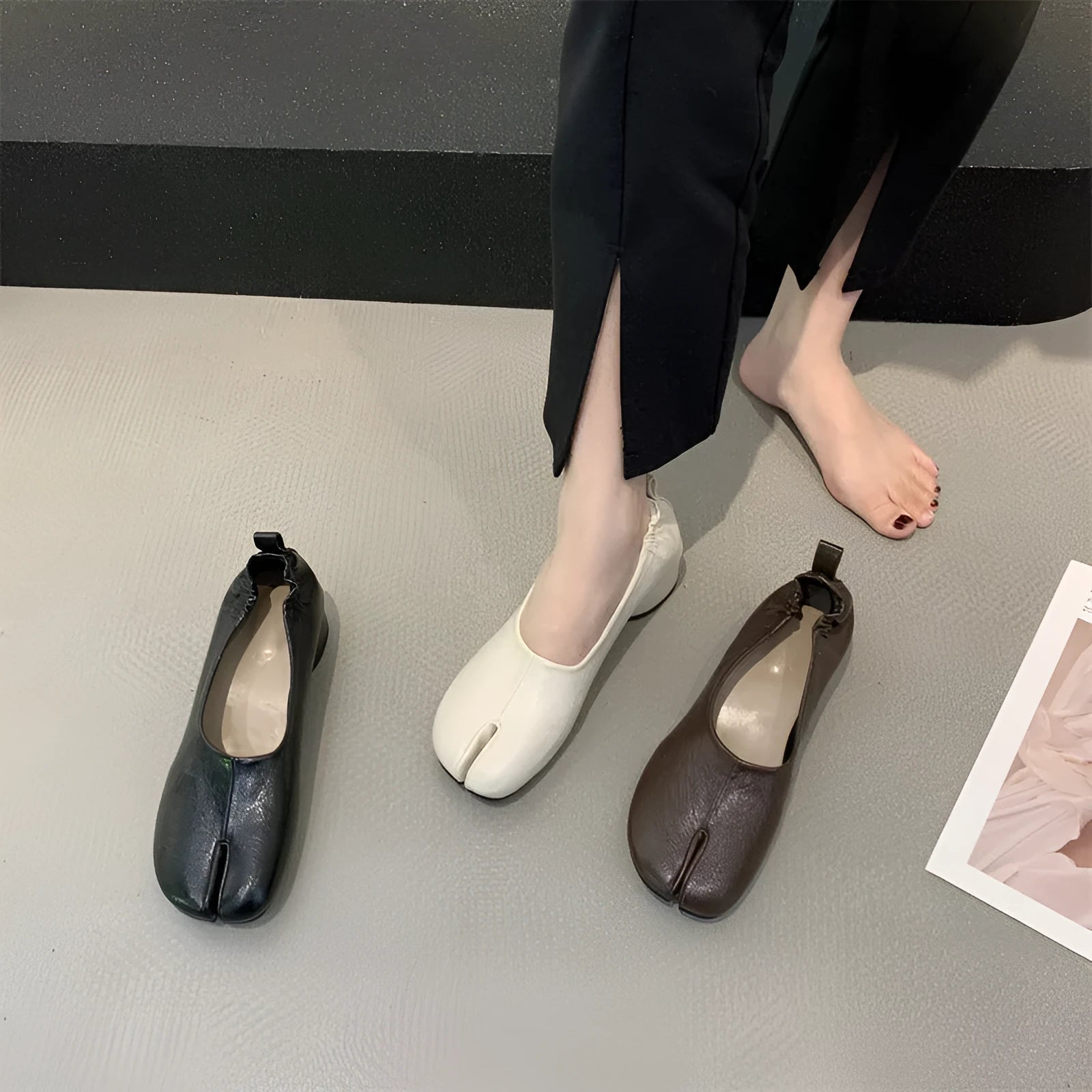 Women's black split toe horseshoe design pumps with a chunky low heel and round toe.