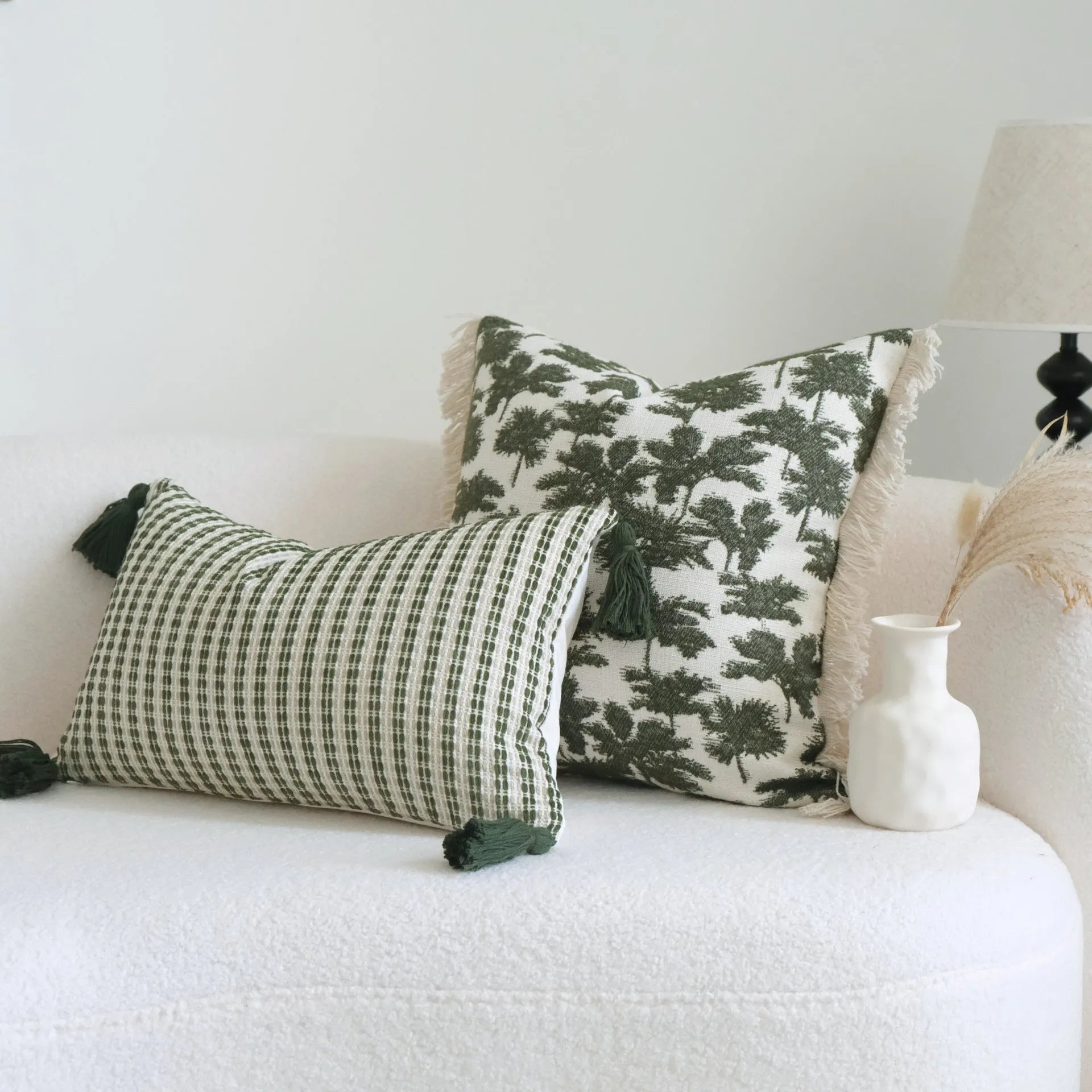 Green cotton linen decorative pillow with tassel, featuring a botanical leaf pattern, for hotel sample rooms.