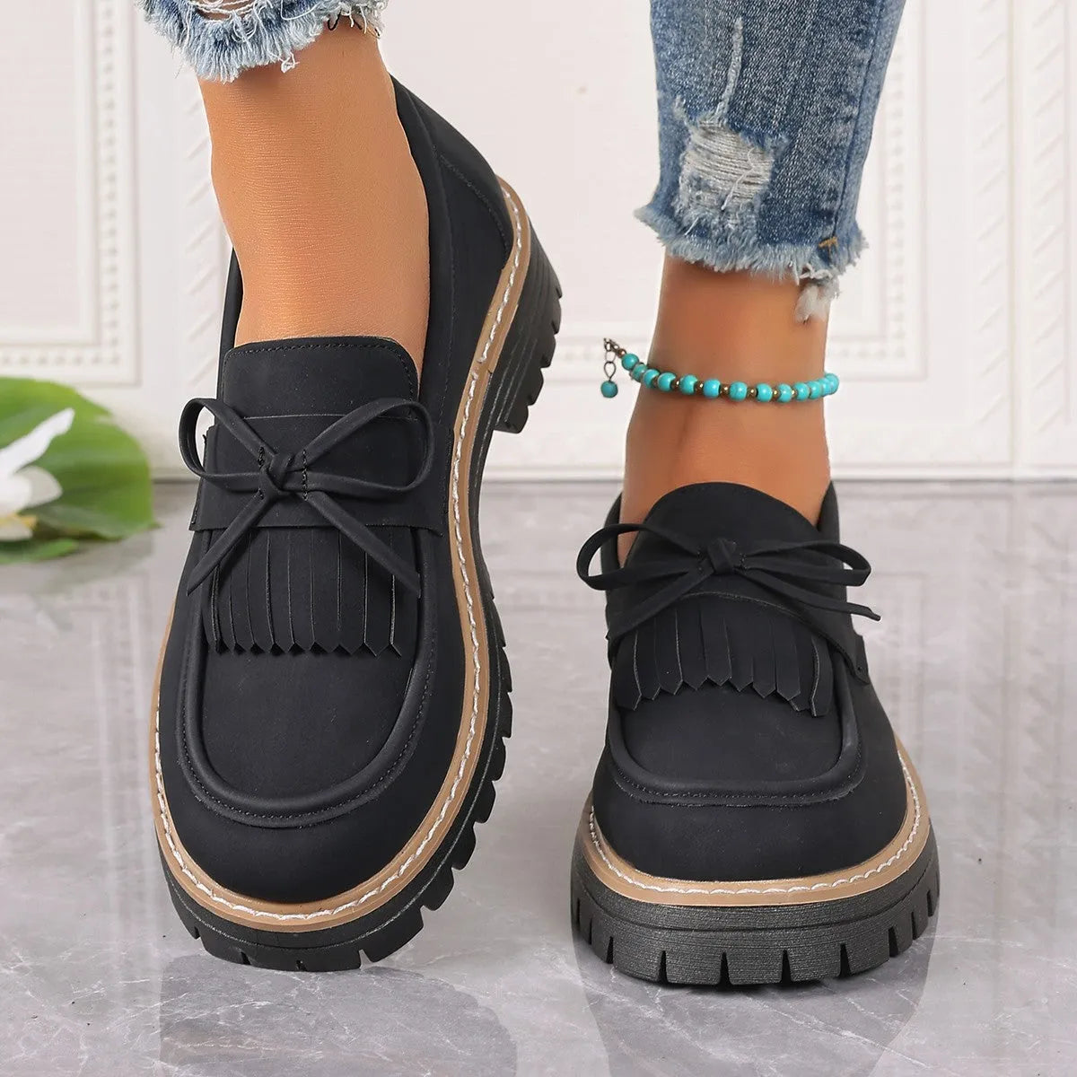 Black plus size women's loafers with a tassel and bowknot on the flat chunky heel.