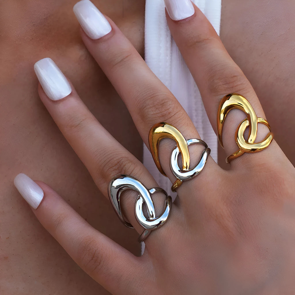 Geometric lines hollow out stainless steel ring with PVD gold plating on a neutral background