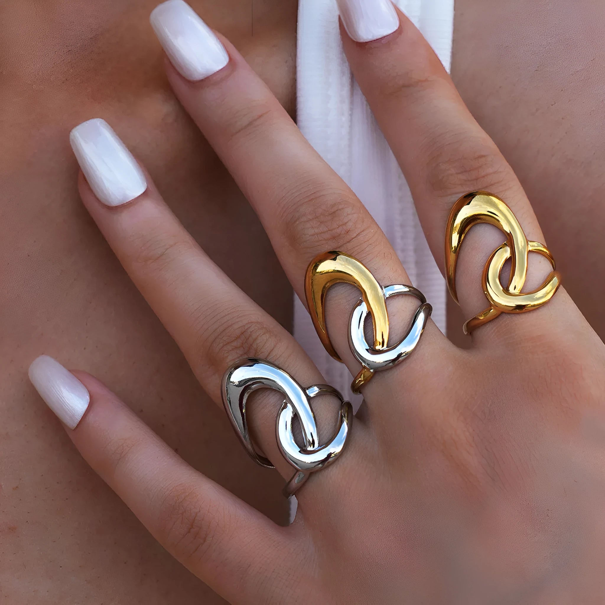 Geometric lines hollow out stainless steel ring with PVD gold plating on a neutral background