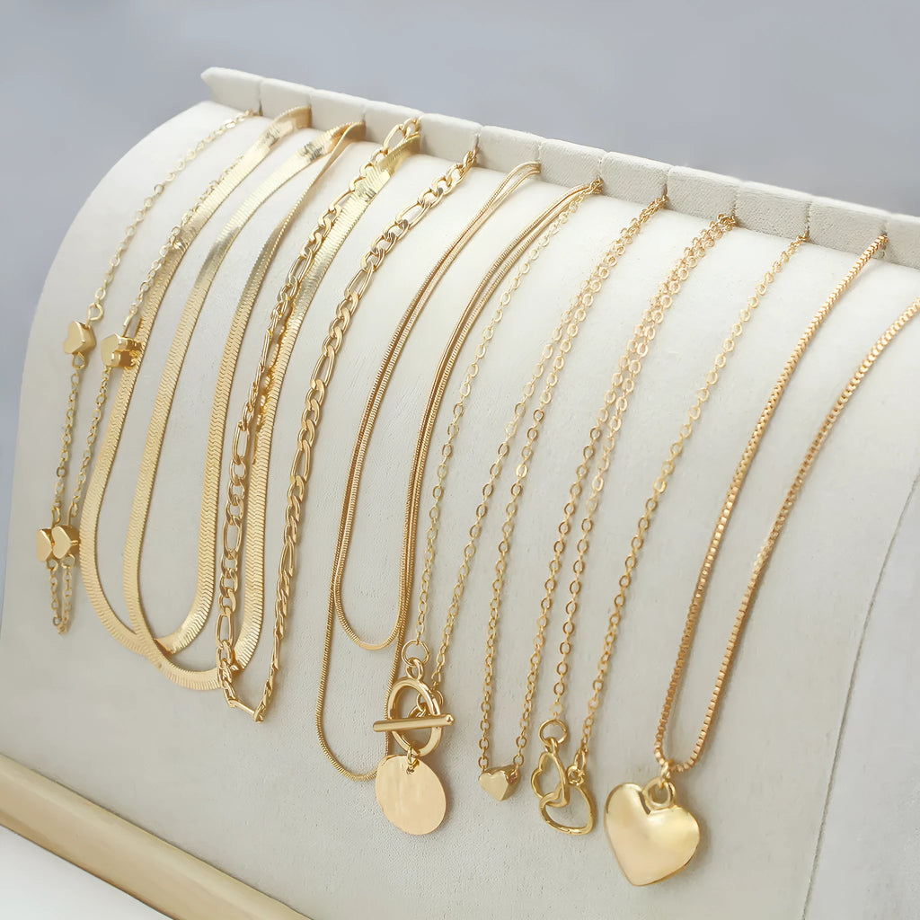 Set of ten gold women's fashion necklaces with snake bone chains and adjustable length on a white background.
