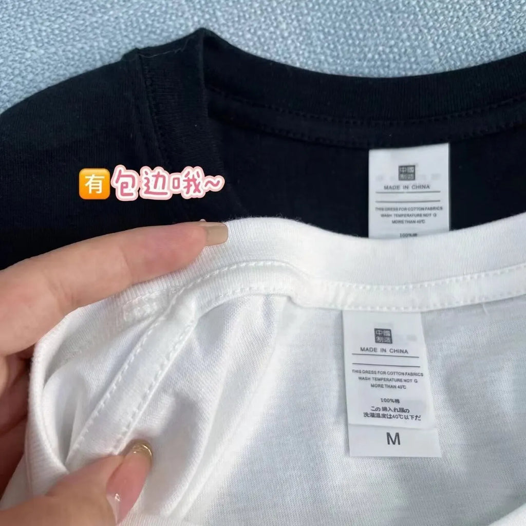 Man wearing a black slim fit pure cotton t-shirt with a simple cartoon print design on the front.