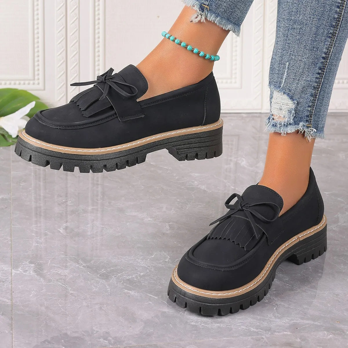 Black plus size women's loafers with a tassel and bowknot on the flat chunky heel.