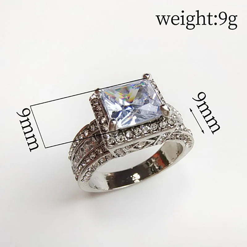 Geometric women's alloy ring with round detail in gold or white electroplated finish on a finger.