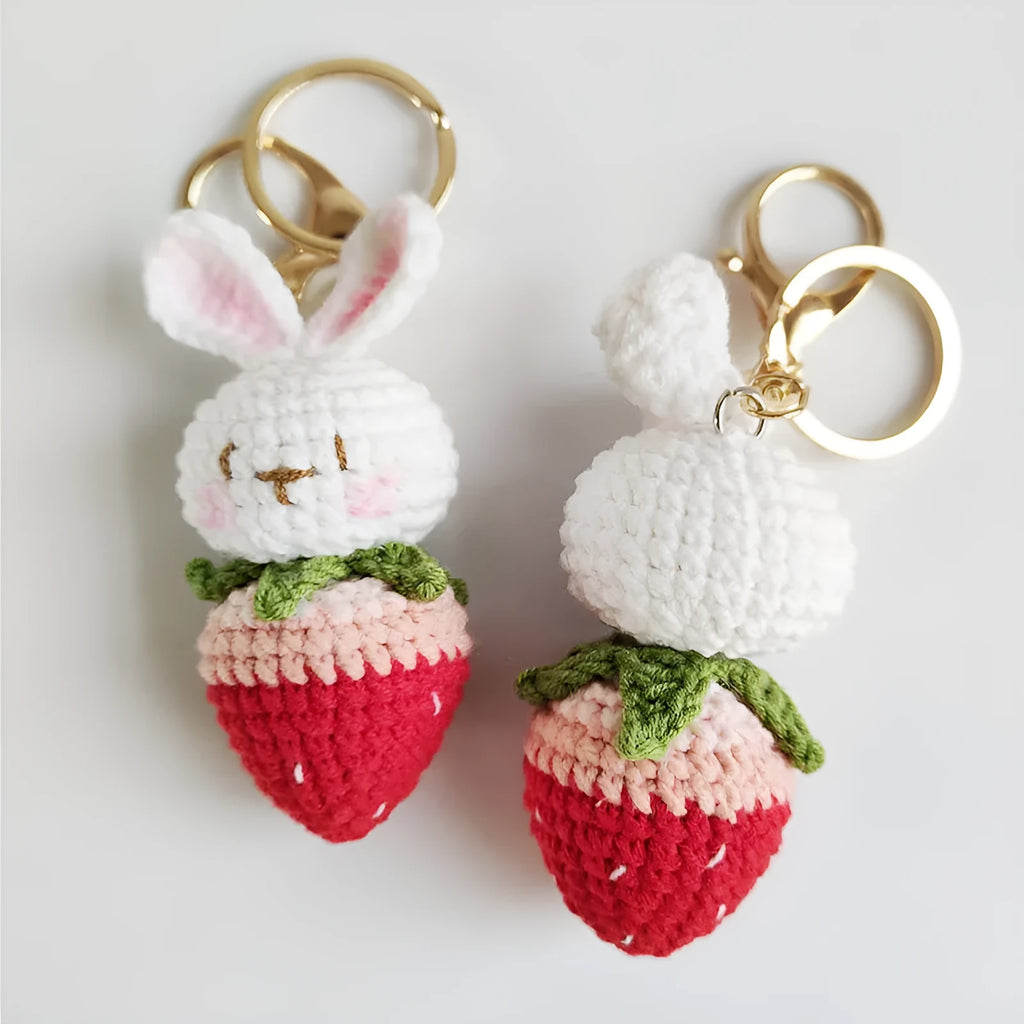 Hand-woven white doll wire pendant with rabbit and strawberry design and an attached key.