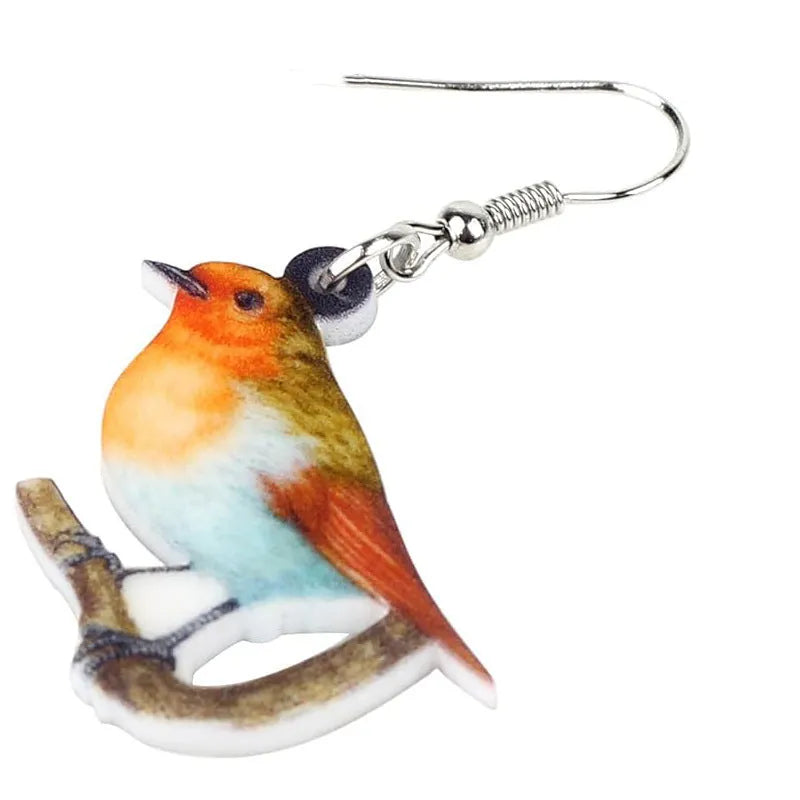 Pair of blue and white acrylic pendant earrings featuring a printed titmouse bird and snake design on geometric shapes.