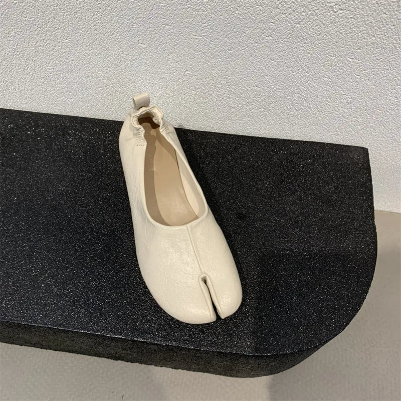 Women's black split toe horseshoe design pumps with a chunky low heel and round toe.