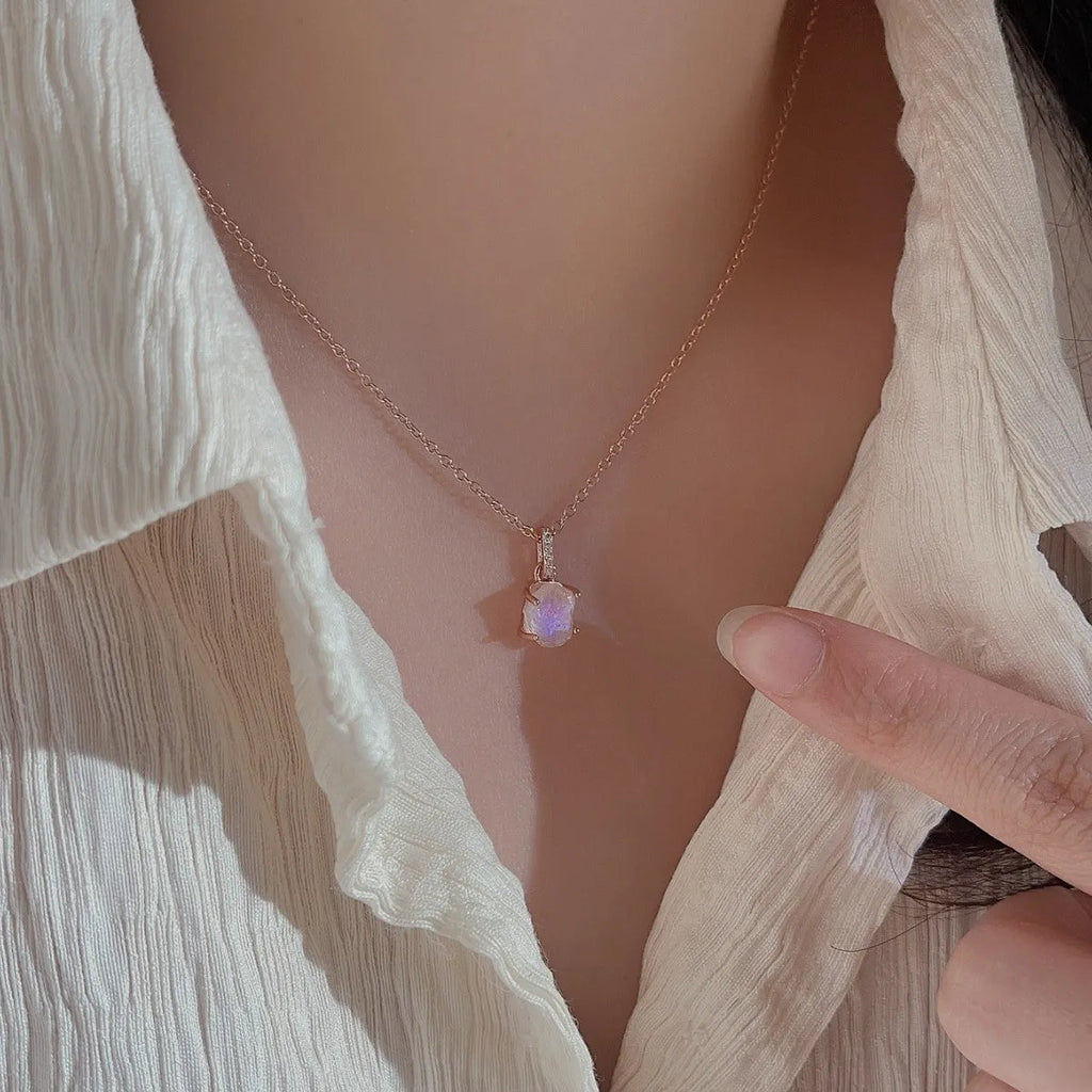 Close-up of a sterling silver necklace with a square moonstone pendant on an adjustable curb chain.