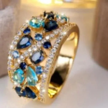Women's round hollow copper fashion ring with a gemstone centrepiece, shown in gold and platinum colour options.