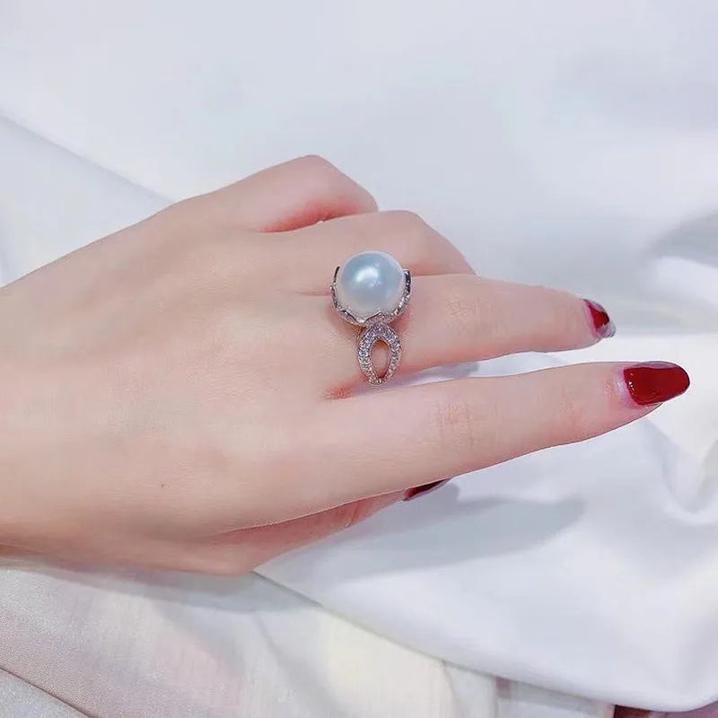 Copper female baroque pearl receptacle ring with inlaid zircon stones in white gold colour on white background