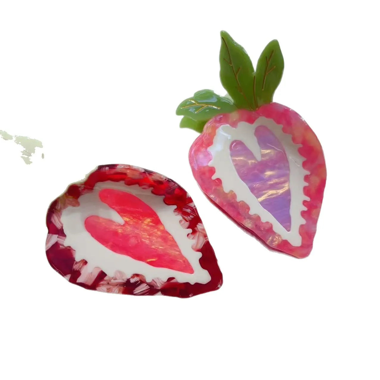 Close-up of a handmade strawberry hairpin in red on a pink background.