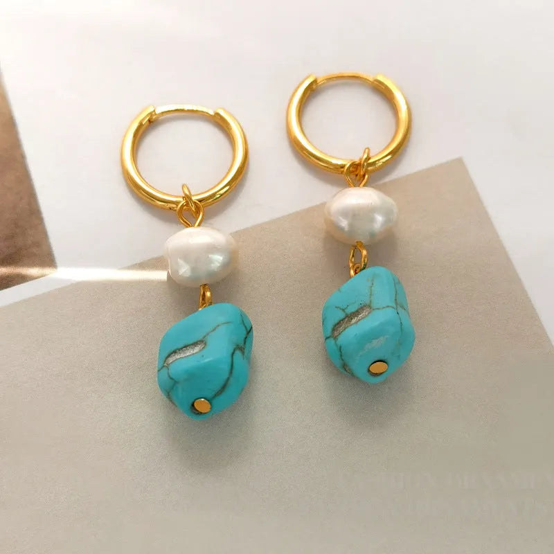 A pair of geometric clip-on earrings made of copper with turquoise and cultured pearls.