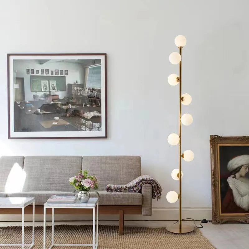 Tall minimalist Nordic floor lamp with wrought iron frame, glass shade, and circular marble base.