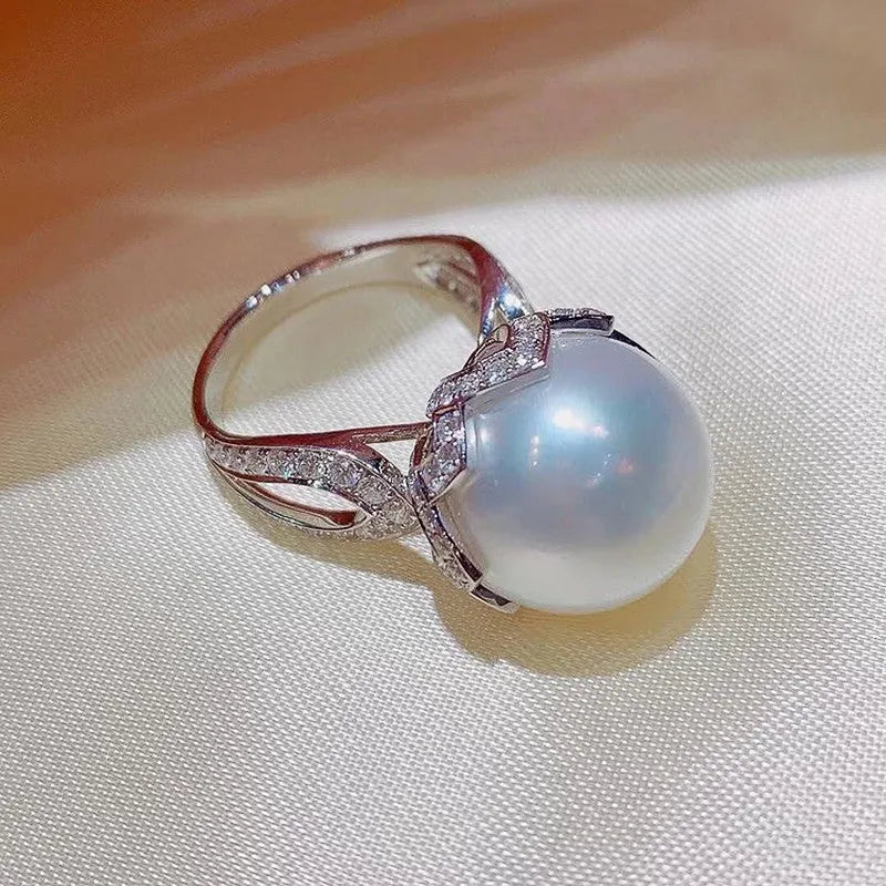 Copper female baroque pearl receptacle ring with inlaid zircon stones in white gold colour on white background