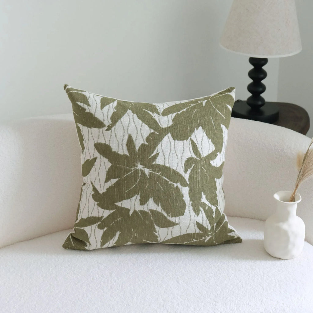 Green cotton linen decorative pillow with tassel, featuring a botanical leaf pattern, for hotel sample rooms.