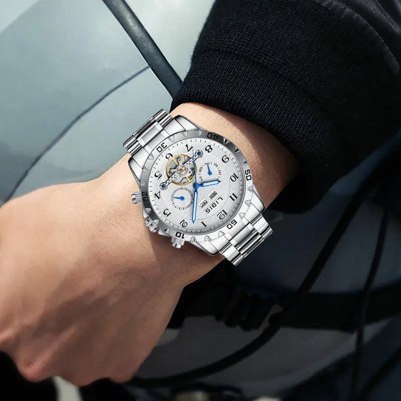 Silver stainless steel men's automatic perpetual calendar watch with sapphire glass on a wrist.