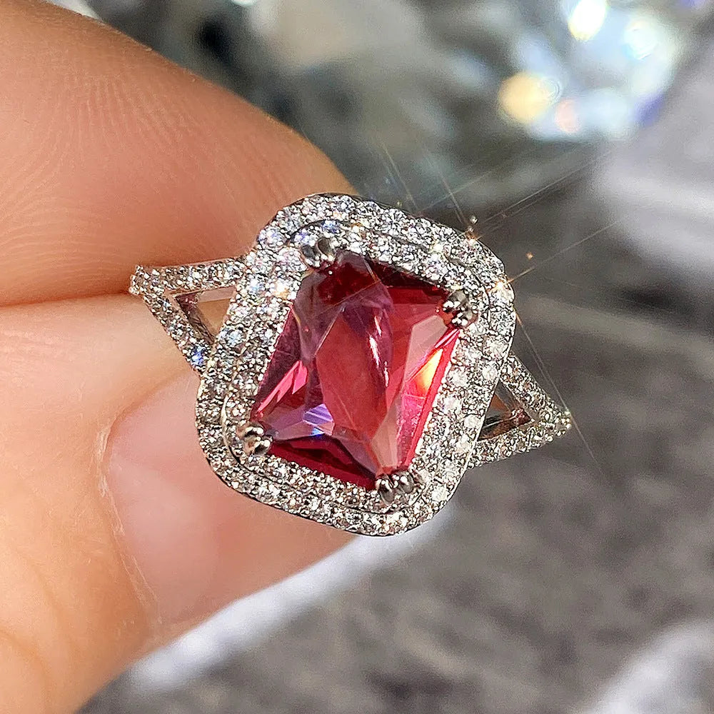 Geometric square red copper ring with a central rhinestone, shown from above.