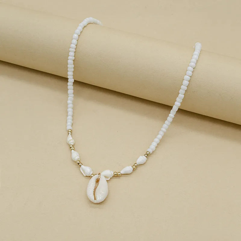 White conch shell bead necklace with a mother of pearl pendant on a regular chain.