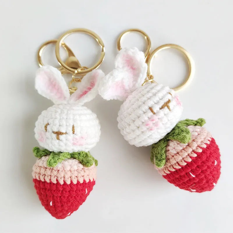 Hand-woven white doll wire pendant with rabbit and strawberry design and an attached key.