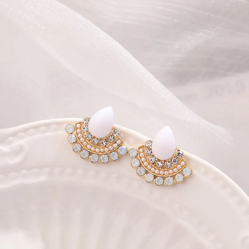 A pair of women's retro fan-shaped silver earrings with geometric rhinestone and needle opal decorative details.