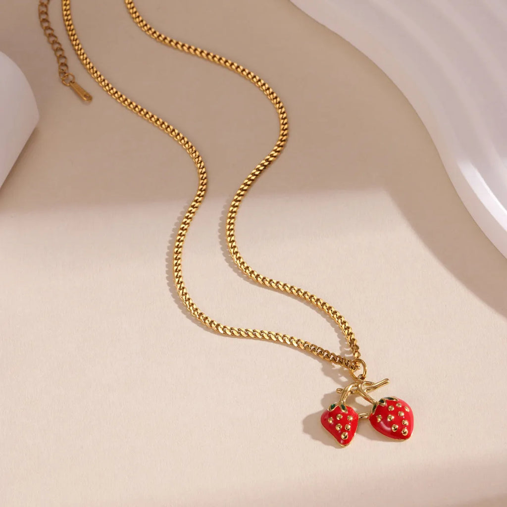 Close-up of a red strawberry pendant necklace on a silver alloy chain with adjustable clasp.
