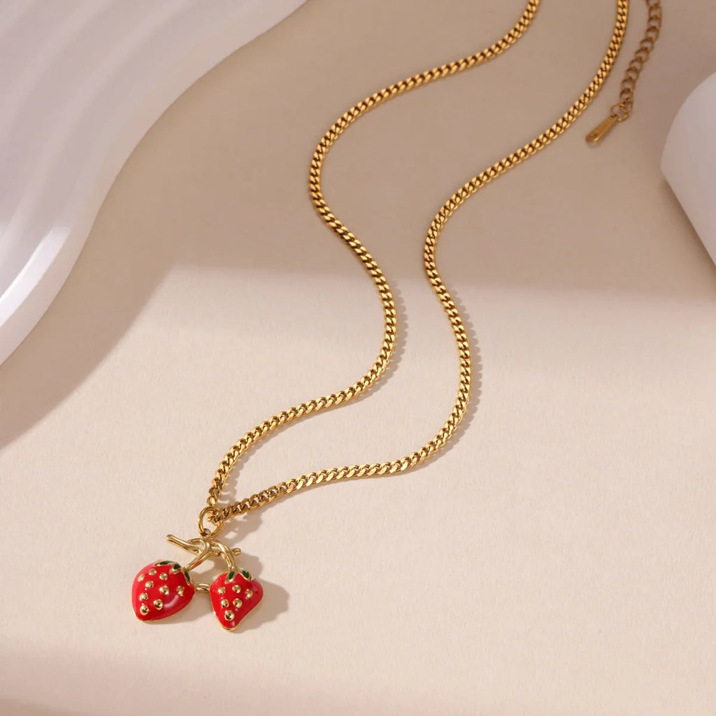 Close-up of a red strawberry pendant necklace on a silver alloy chain with adjustable clasp.