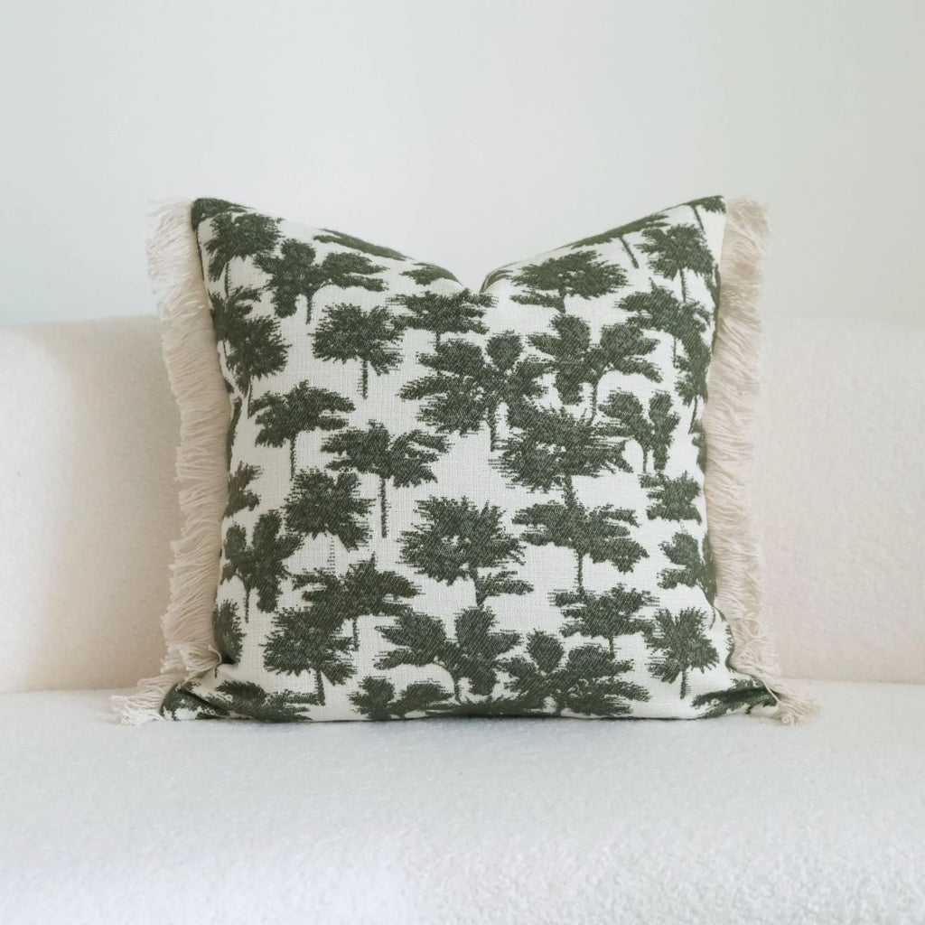 Green cotton linen decorative pillow with tassel, featuring a botanical leaf pattern, for hotel sample rooms.