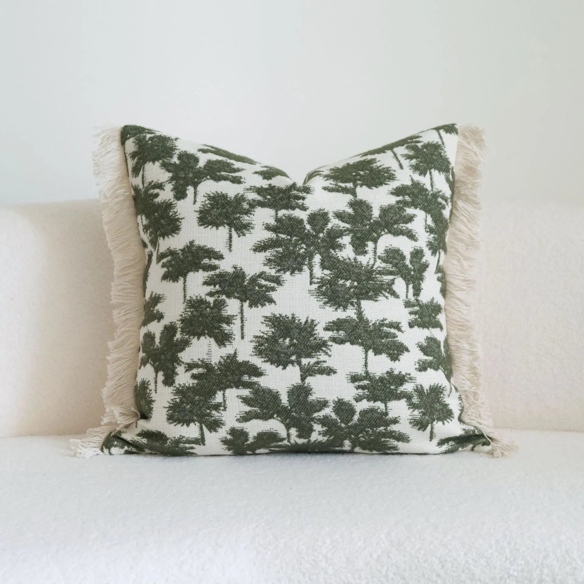Green cotton linen decorative pillow with tassel, featuring a botanical leaf pattern, for hotel sample rooms.