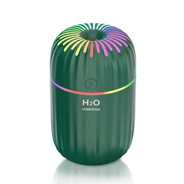 Green mini car USB aromatherapy humidifier on a desk with USB cable.