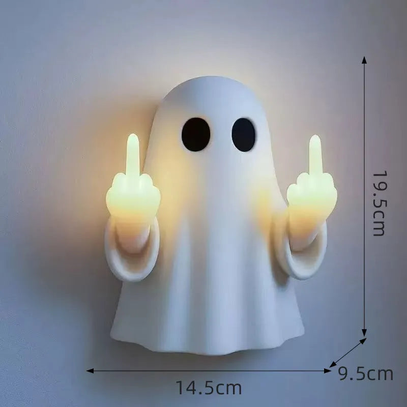 White plastic ghost statue night lamp for Halloween decoration on a dark surface.