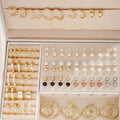 Assortment of 108 gold and yellow geometric alloy earrings with round pearl-like details on a white background.