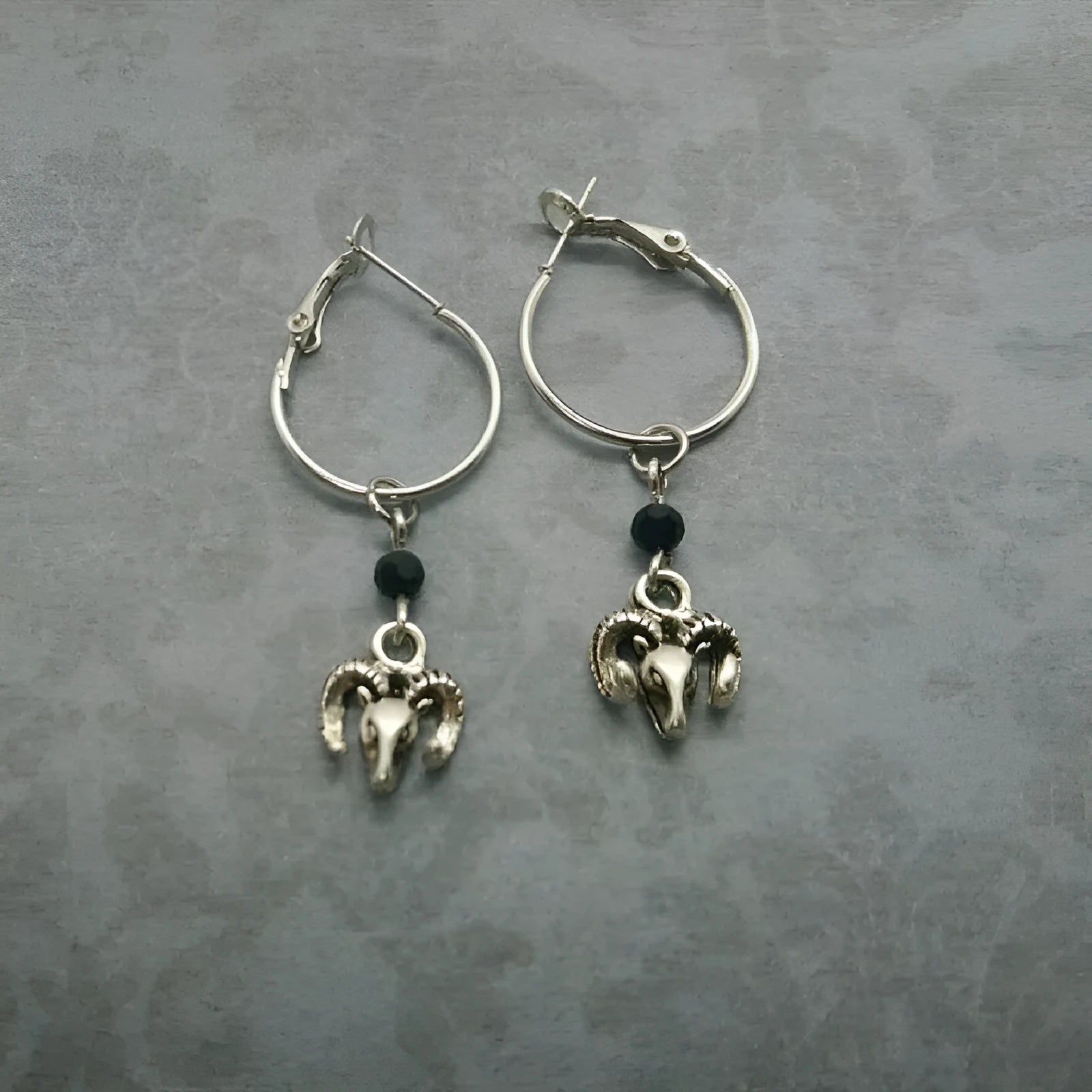 Silver-coloured alloy round hoop earrings for women with a Tibetan antelope design detail.