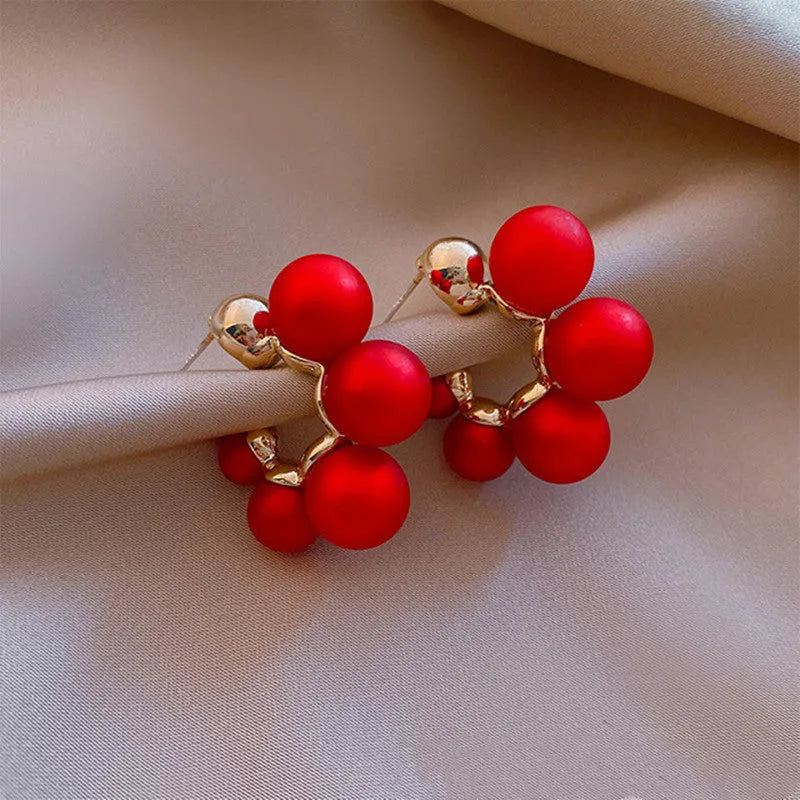 A pair of red bell-shaped drop earrings for women, made from metal alloy.