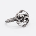 Steel coloured titanium steel double snake ring with a retro design on a finger.