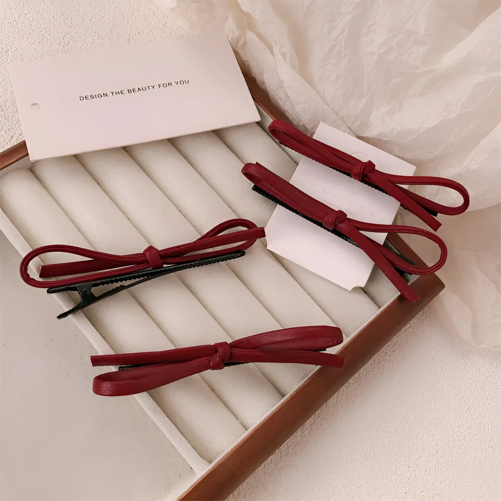 Wine red genuine leather bow hair barrette with metal clip on a white background.