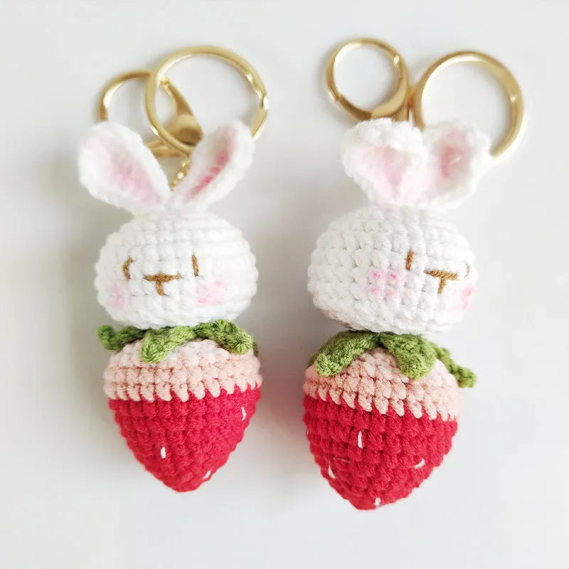Hand-woven white doll wire pendant with rabbit and strawberry design and an attached key.