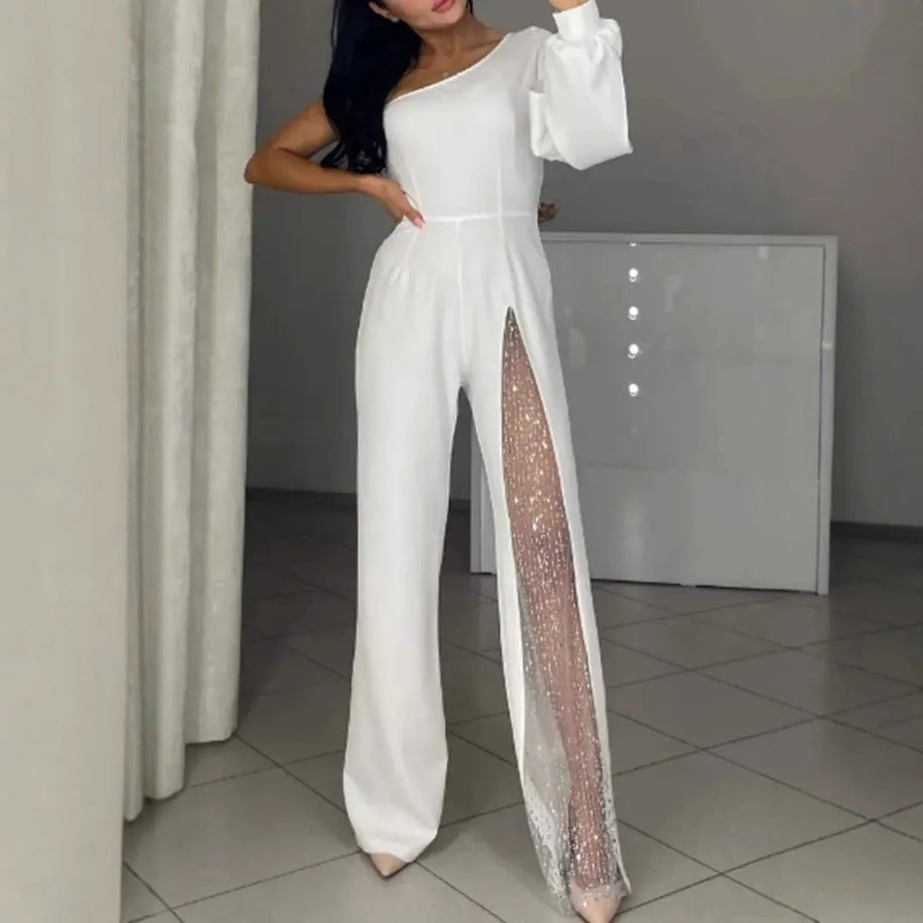 A woman wearing a black polyester jumpsuit with an oblique shoulder neckline and a high leg slit.