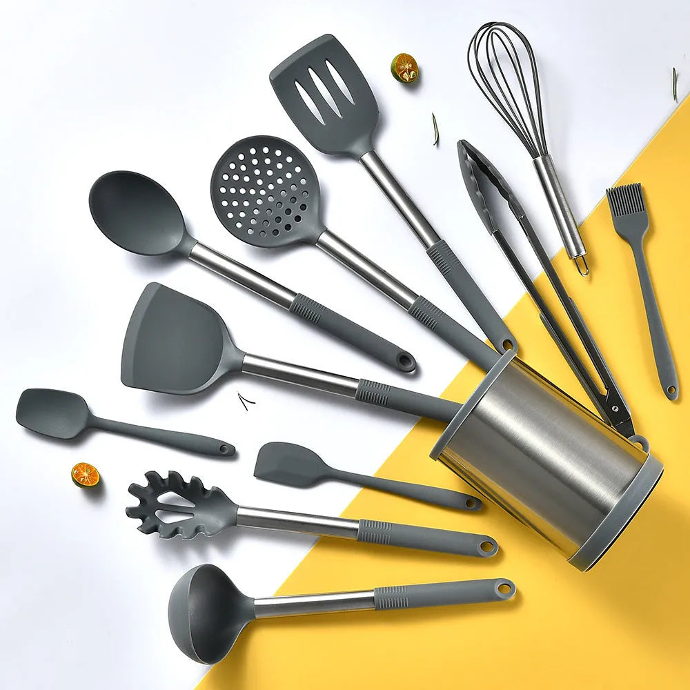 12-piece black silicone kitchen utensil set including spatula, spoon, and claw tools in a rotating storage bucket on a kitchen counter.