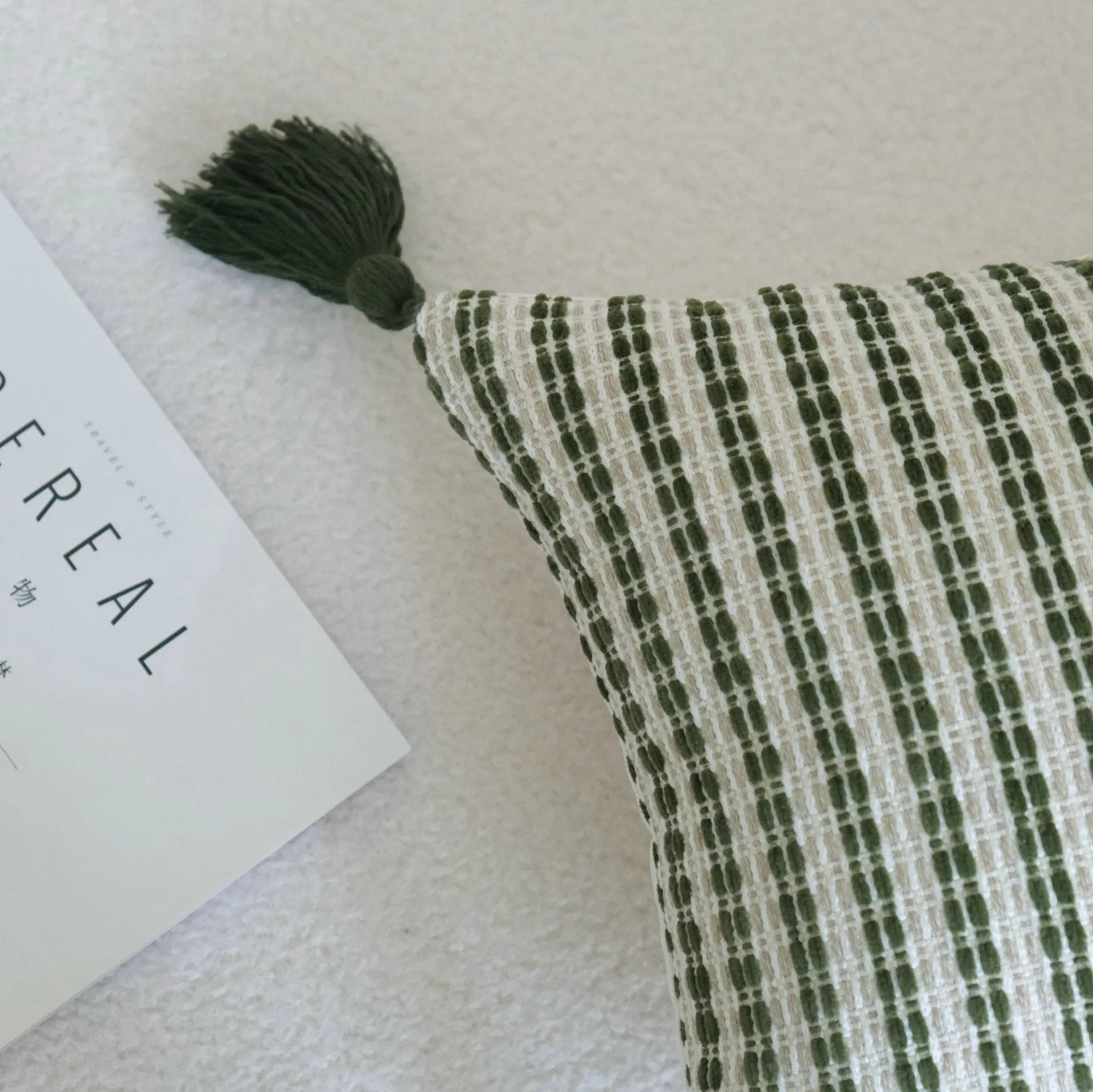Green cotton linen decorative pillow with tassel, featuring a botanical leaf pattern, for hotel sample rooms.