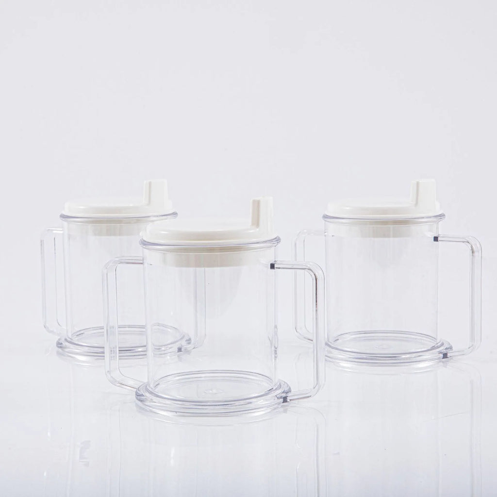 Transparent spill-proof plastic drinking cup on a plain background