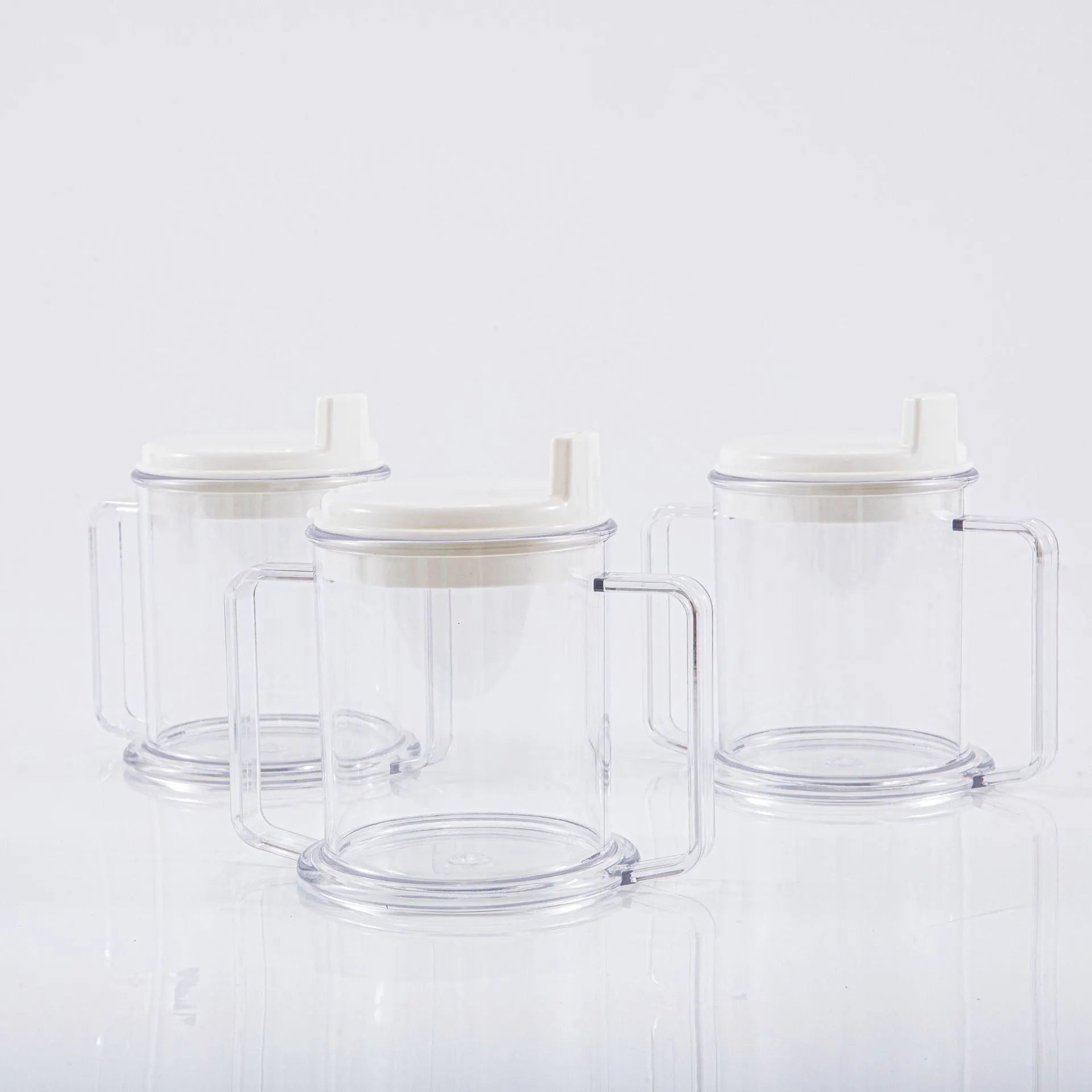 Transparent spill-proof plastic drinking cup on a plain background