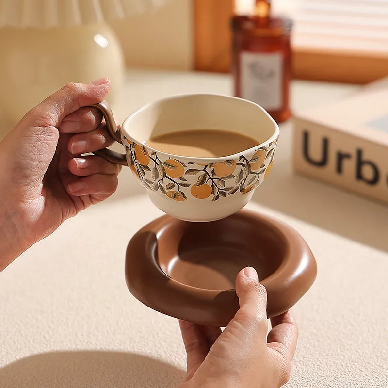 Antique-style ceramic coffee cup and saucer set with a retro pattern in either black or orange.