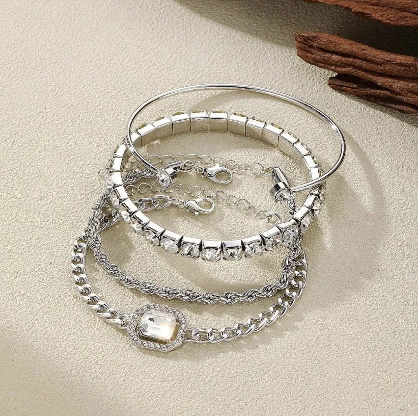 Set of four women's alloy bracelets with geometric square diamond charms and metal chains in gold or silver.