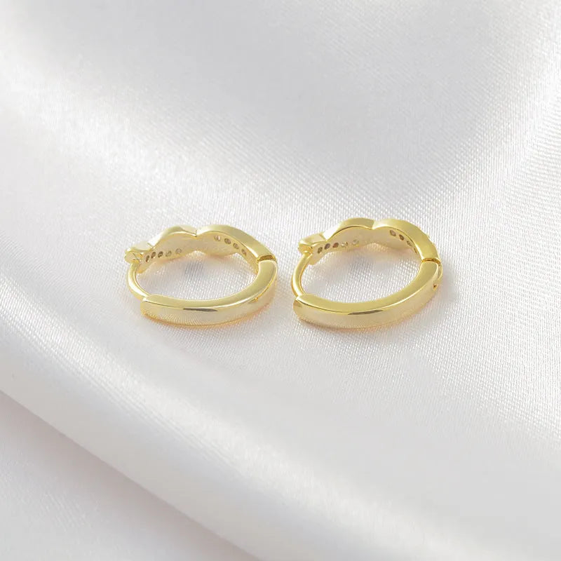 Gold geometric interwoven hemp rope earclip earrings on a white background