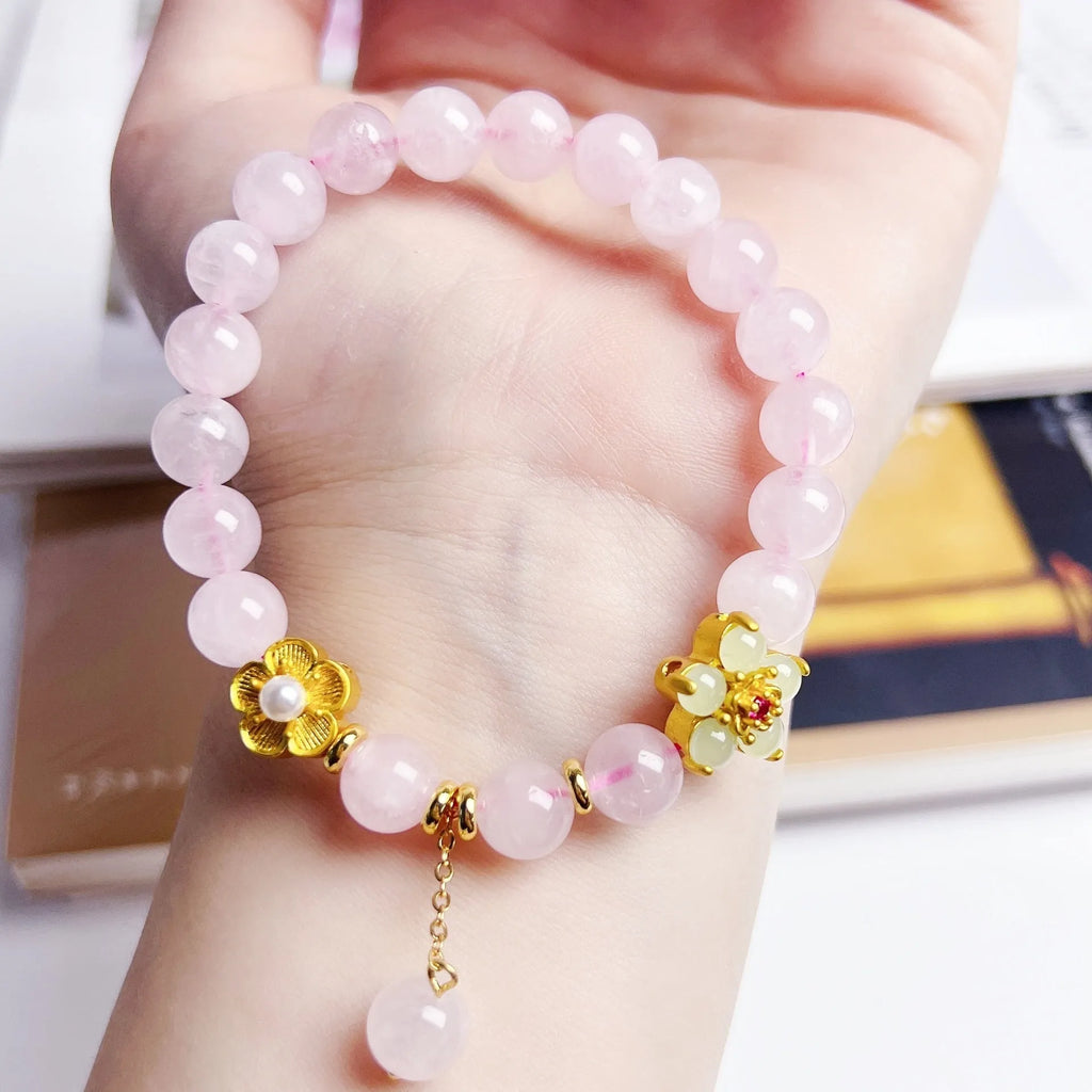 Pink crystal peach blossom bracelet with adjustable clasp on woman's wrist